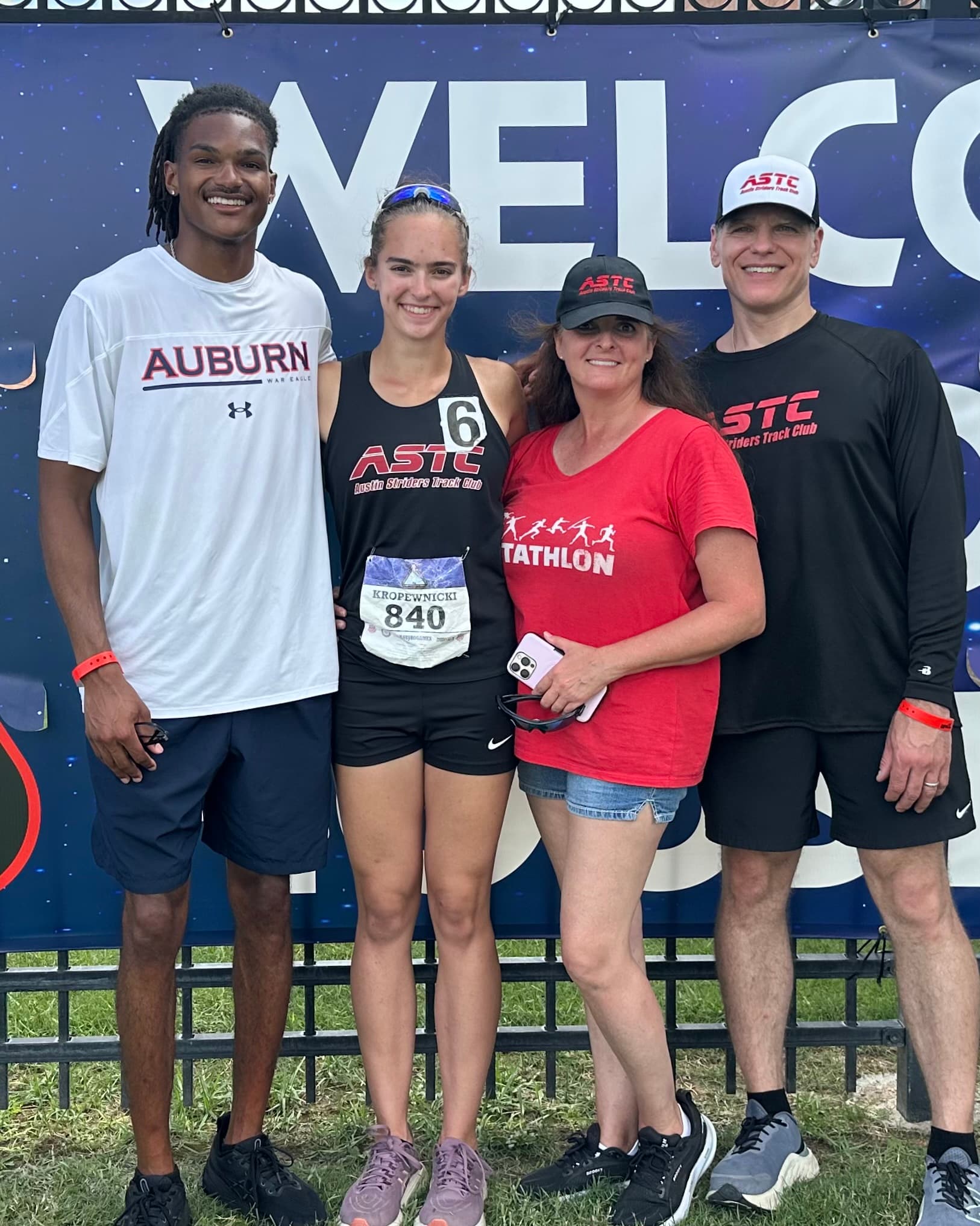 Coach Dontavious Hill with an athlete and her parents at a track meet