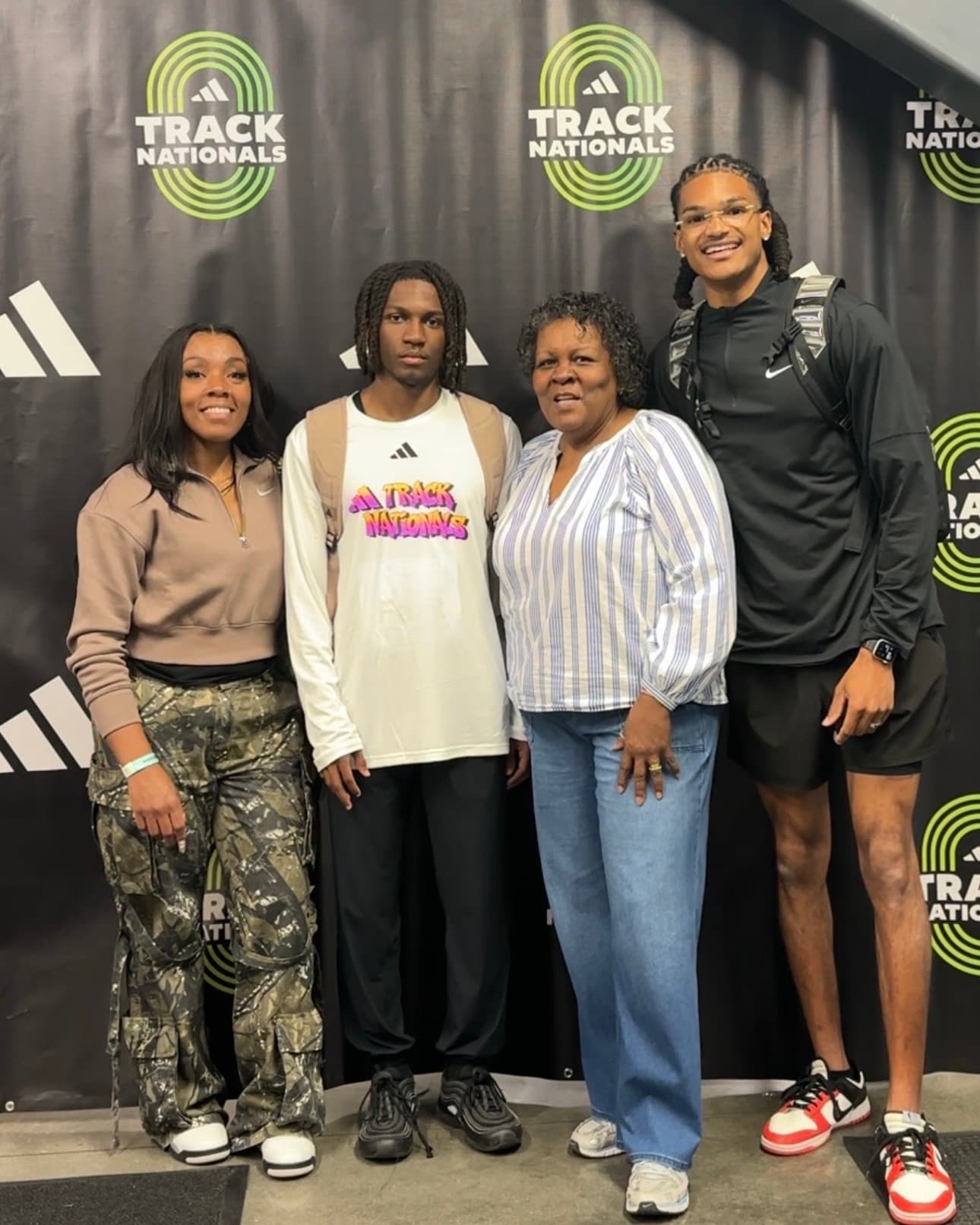 Coach Dontavious Hill with an athlete and a family member at Track Nationals