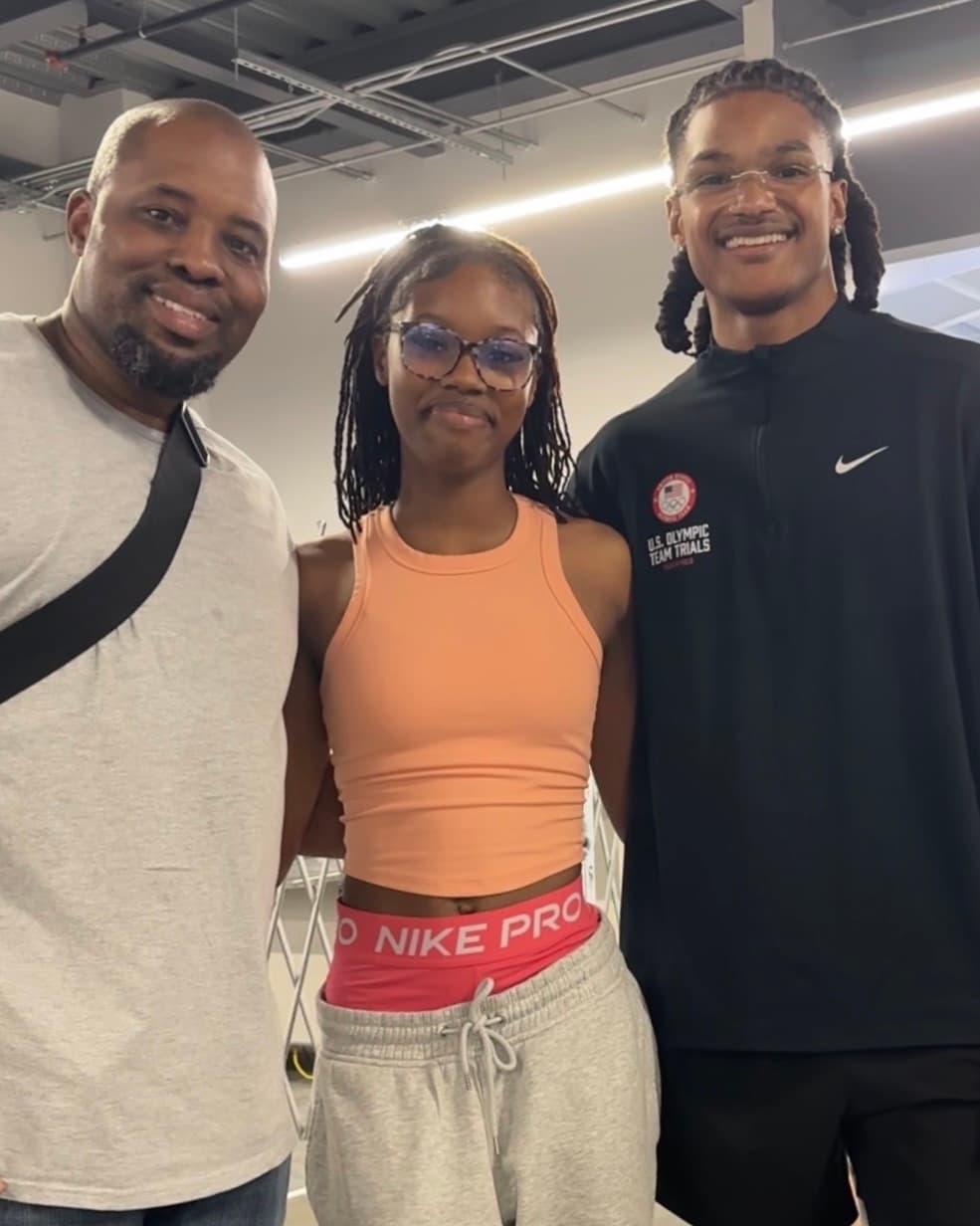 Coach Dontavious Hill with an athlete and her father at a training facility