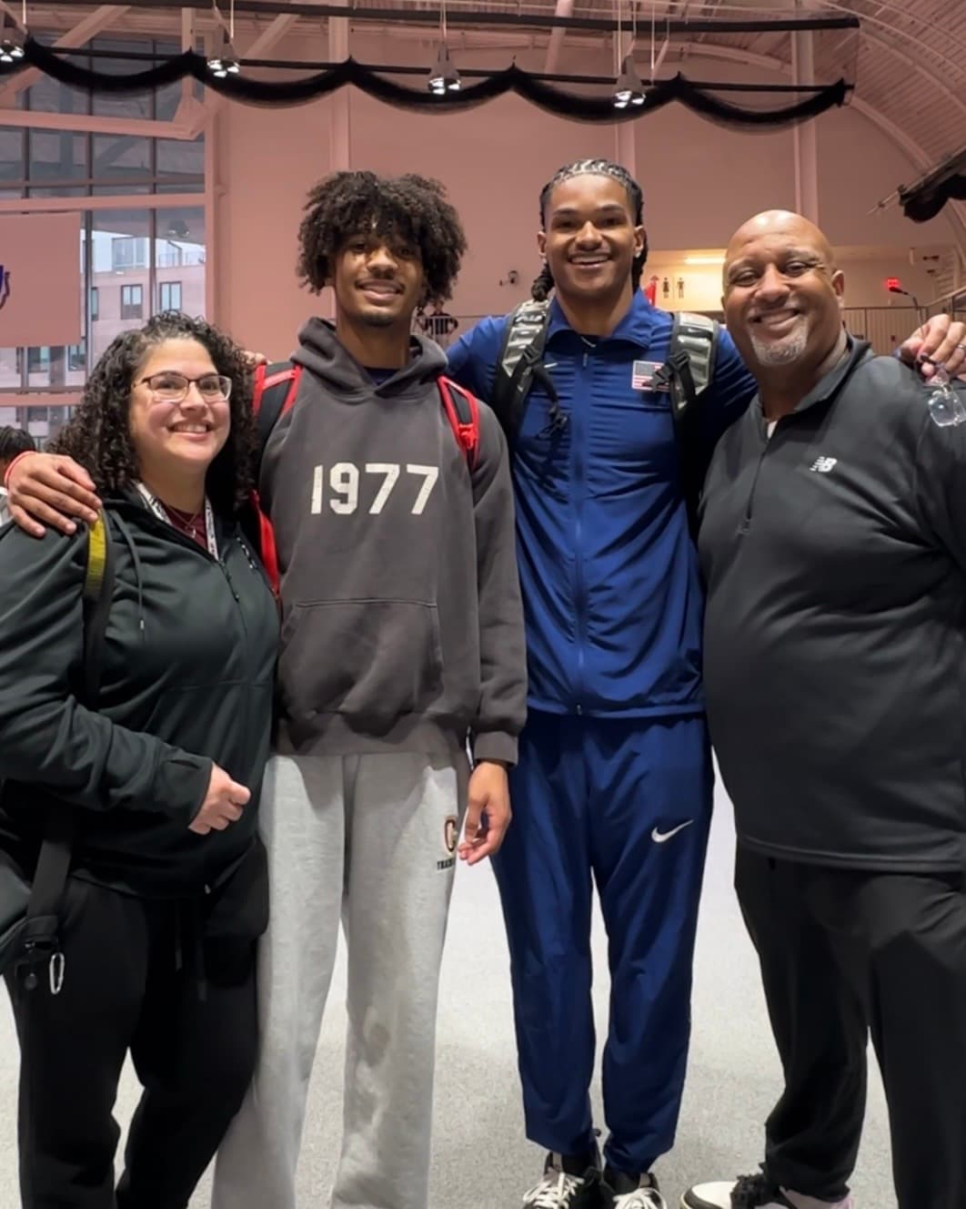 Dontavious Hill with an athlete and both parents at a track venue